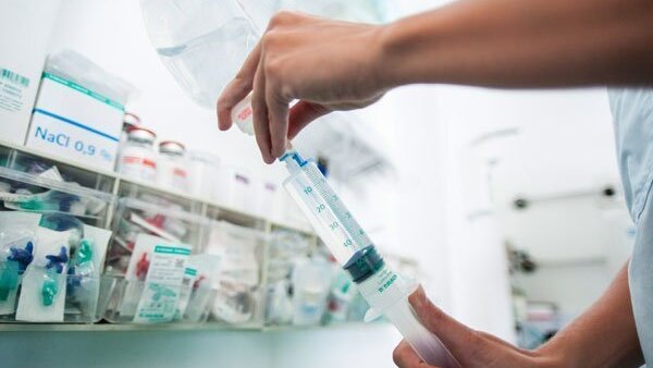 Researcher draws up liquid in a syringe